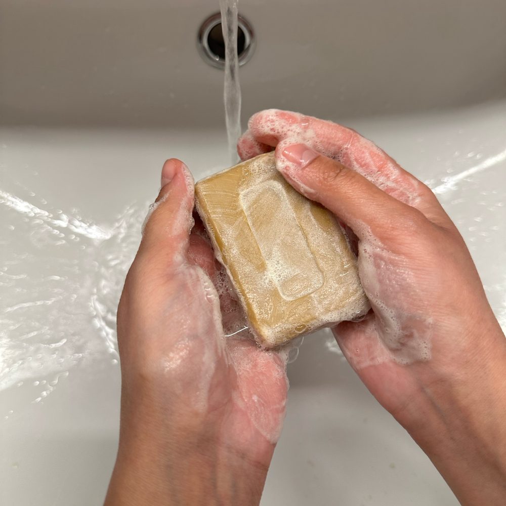 Savon à l'huile d'argan Glowytime utilisé sous l'eau avec mousse.